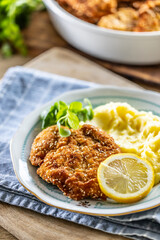 Traditional schnitzel with potato mash and green salad served on a plate