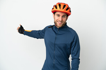 Young cyclist man isolated on white background extending hands to the side for inviting to come