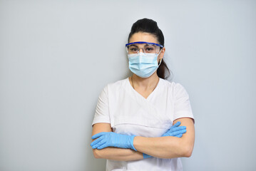 Cute woman dentist in uniform, protective glasses and face mask
