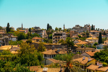 Roofs of a Mediterranean town against the background of the blue sea and mountains in the distance. The concept of a holiday at the sea in summer.