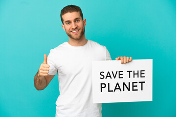 Handsome blonde man over isolated blue background holding a placard with text Save the Planet with...