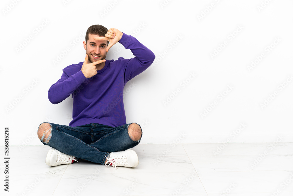 Canvas Prints Young man sitting on the floor focusing face. Framing symbol