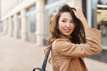 Natural attractive asian kazakh female wearing beige coat, posing on camera