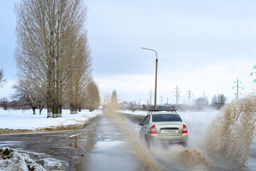 Motion car, big puddle of water spray from the wheels.