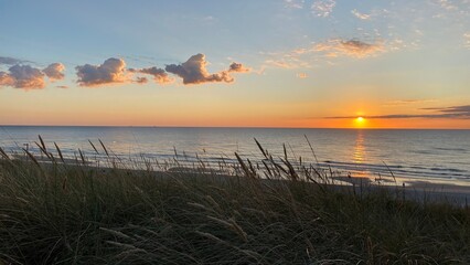 Sunset over the North Sea with dune grass in front on the island of Sylt in Germany	