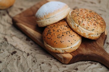 Freshly baked burger buns on wooden board