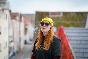 Fototapeta premium Female Hipster on balcony urban city background