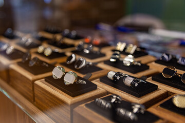 Boxes with cufflinks on shelf in boutique.