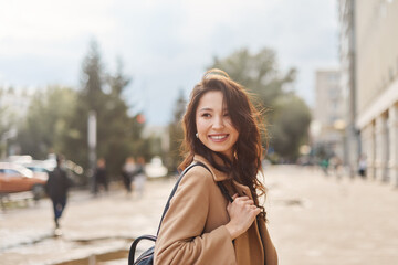 Lifestyle portrait pretty Asian kazakh woman with brilliant smile on street