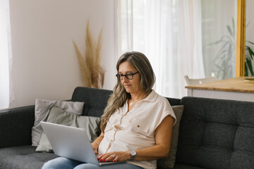 Adult woman working from home using laptop