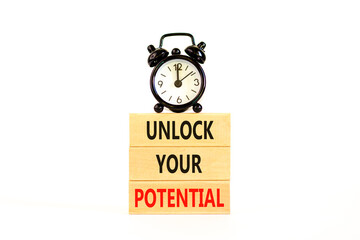 Unlock your potential symbol. Concept words Unlock your potential on wooden blocks. Black alarm clock. Beautiful white background. Business, psychological unlock your potential concept. Copy space.