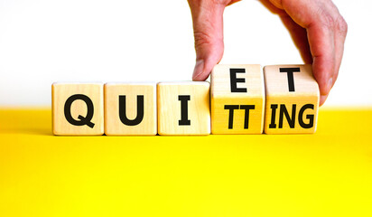 Quiet quitting symbol. Concept words Quiet quitting on wooden cubes. Businessman hand. Beautiful yellow table white background. Business quiet quitting concept. Copy space.