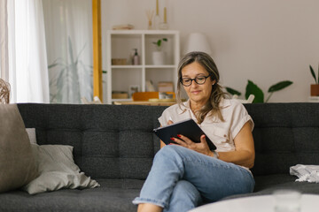 Adult woman having video call at home using tablet