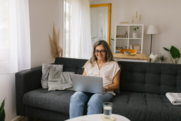 Adult woman using laptop at home for online meeting