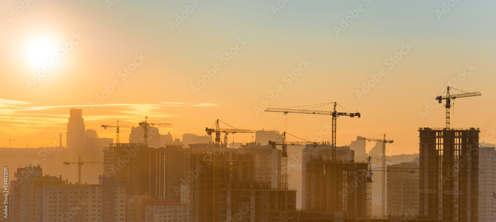 Wall mural construction site panorama with industrial cranes in city at sunset