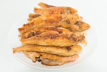 Dish of fried fishes red mullets isolated on white background