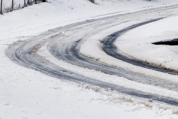 Traces of the car on a snowy road in winter