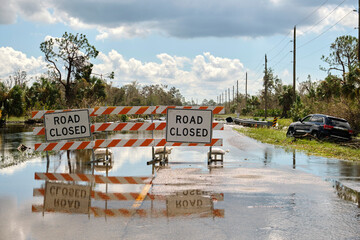 Road closed for roadworks and danger of flooding with warning signs blocking driving of cars