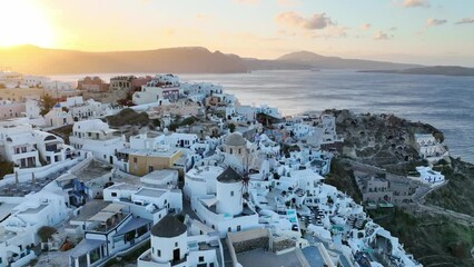 Santorini island in Greece, aerial view of famous Oia town on Santorini at sunrise, Greek tourist destination, windmill in Oia, Santorini