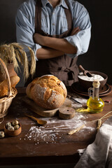 Baker man and bread with bakery ingredients for homemade bread cooking at table. Bakery concept