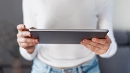 woman with pc tablet in hands indoors, closeup