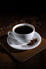 Cup of coffee with beans at wooden table