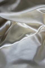 Beautiful white mother-of-pearl fabric, folded in folds. Silk, satin or satin ribbon.