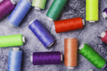 Sewing threads on bobbins. On a gray concrete background.