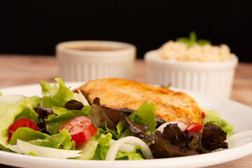 Healthy salad with chicken on a plate, lettuce, and organic vegetables,