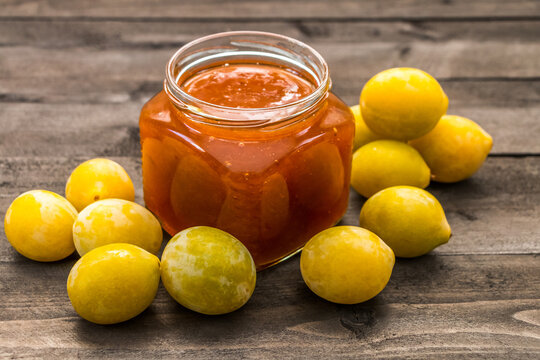 yellow plums on the table and a jar of plum jam