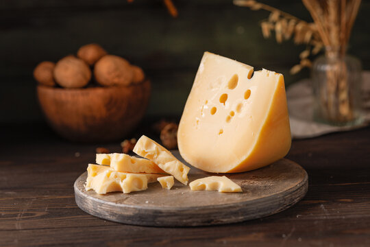 cheese with eyes on a wooden board on the table.
