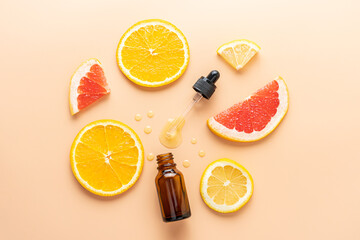Cosmetic organic, vitamin C extract. Slice of grapefruit, orange, lemon and serum dropper bottle on beige background, top view - obrazy, fototapety, plakaty