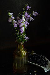 Flowers and leaves in a vase on a black background.
