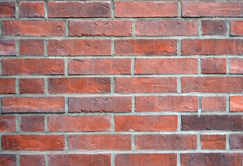 Red brick wall background close-up. Even red and brown bricks. Texture of a brick wall for wallpapers, slides, screensavers and other types of backgrounds