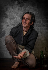 Black hair man with alcohol near old brick wall