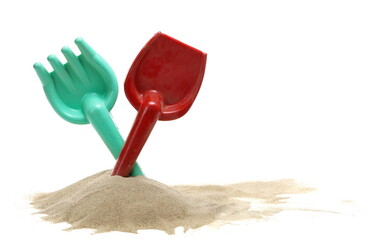 Plastic shovel and rake, beach toy for kids in sand pile, isolated on white  