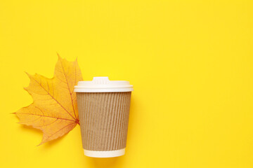 Layout of Disposable Paper To Go Coffee tea Cup for Hot Cold Drink on yellow background with fallen autumn leaf. Coffee break concept. Fall concept. Top view. Flat lay. Copy space, Space for text
