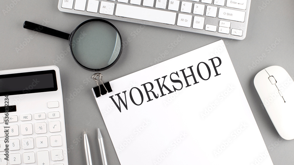 Poster workshop written on paper with office tools and keyboard on the grey background