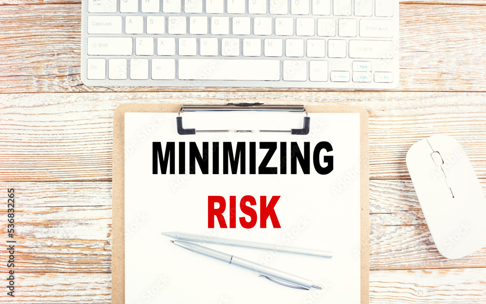 Poster minimizing risks text on paper with calculator, notepad, coffee ,pen with graph