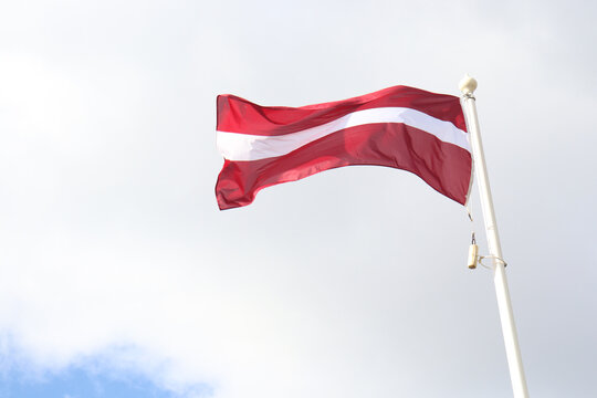Latvian national flag banding/waving in the sky.