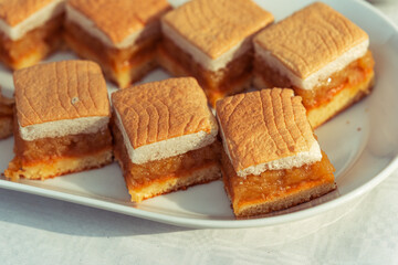 apple pie pieces with egg white foam, pastry on white plate, autumn backing, slice of sweet cake