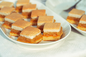 apple pie pieces with egg white foam, pastry on white plate, autumn backing, slice of sweet cake