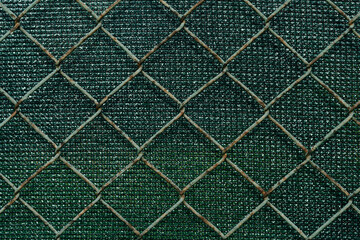 Metal grid on green background. Pattern. Protective fence against thieves, home railing with farbic, Selective focus