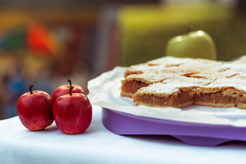 apple pie pieces sprinkled with powdered sugar, pastry on white plate, autumn backing, slice of...