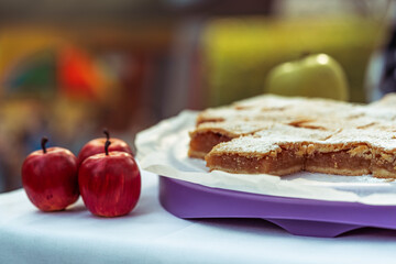 apple pie pieces sprinkled with powdered sugar, pastry on white plate, autumn backing, slice of...
