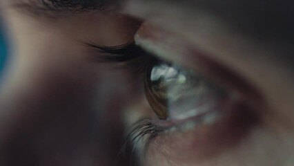 Macro eye of a boy in the night watching tv