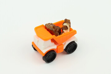 Naklejka premium Walnut pieces in a small orange toy truck bed, white background