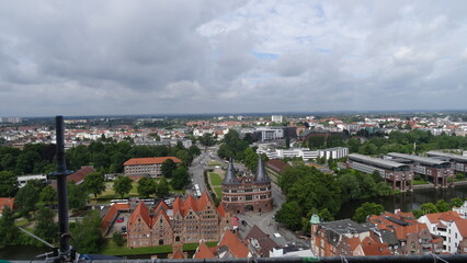 Naklejka na ściany i meble Lübeck, sky, clouds, buildings, trees and the holstentor at germany