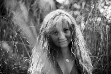 Portrait of a long-haired Slavic woman in a summer village. Black and white photo.