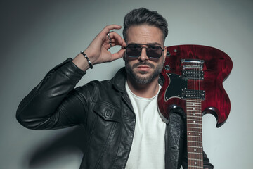 sexy rock singer carrying his electric guitar on his shoulder